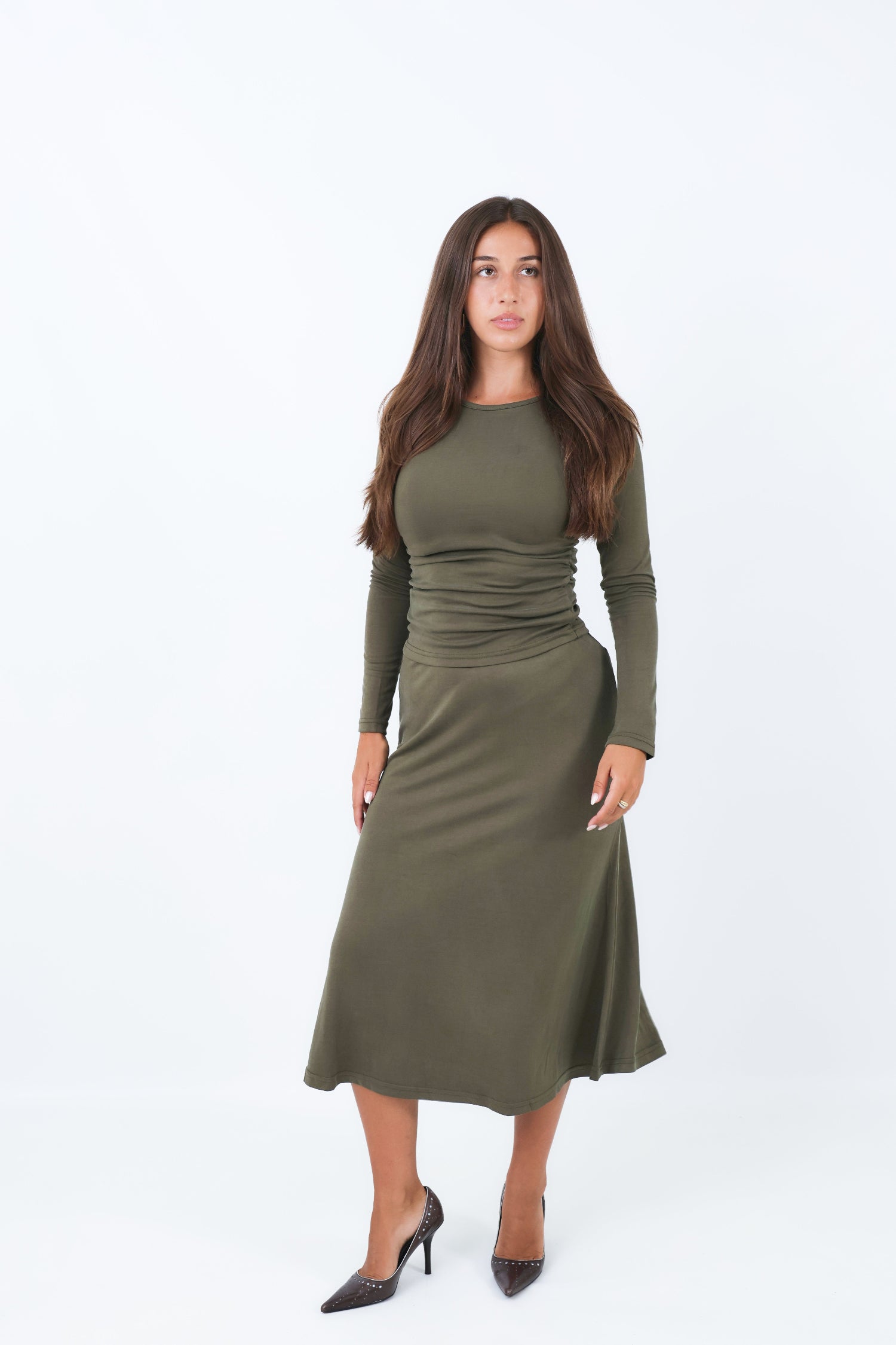 Woman wearing a utility green skirt and matching shirt on a white background