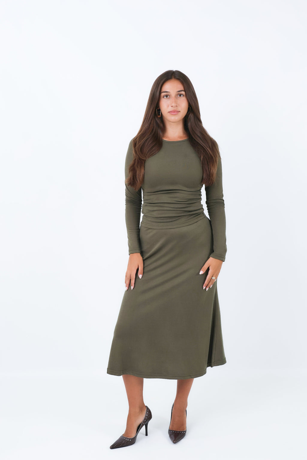 Woman wearing a utility green skirt and matching shirt on a white background