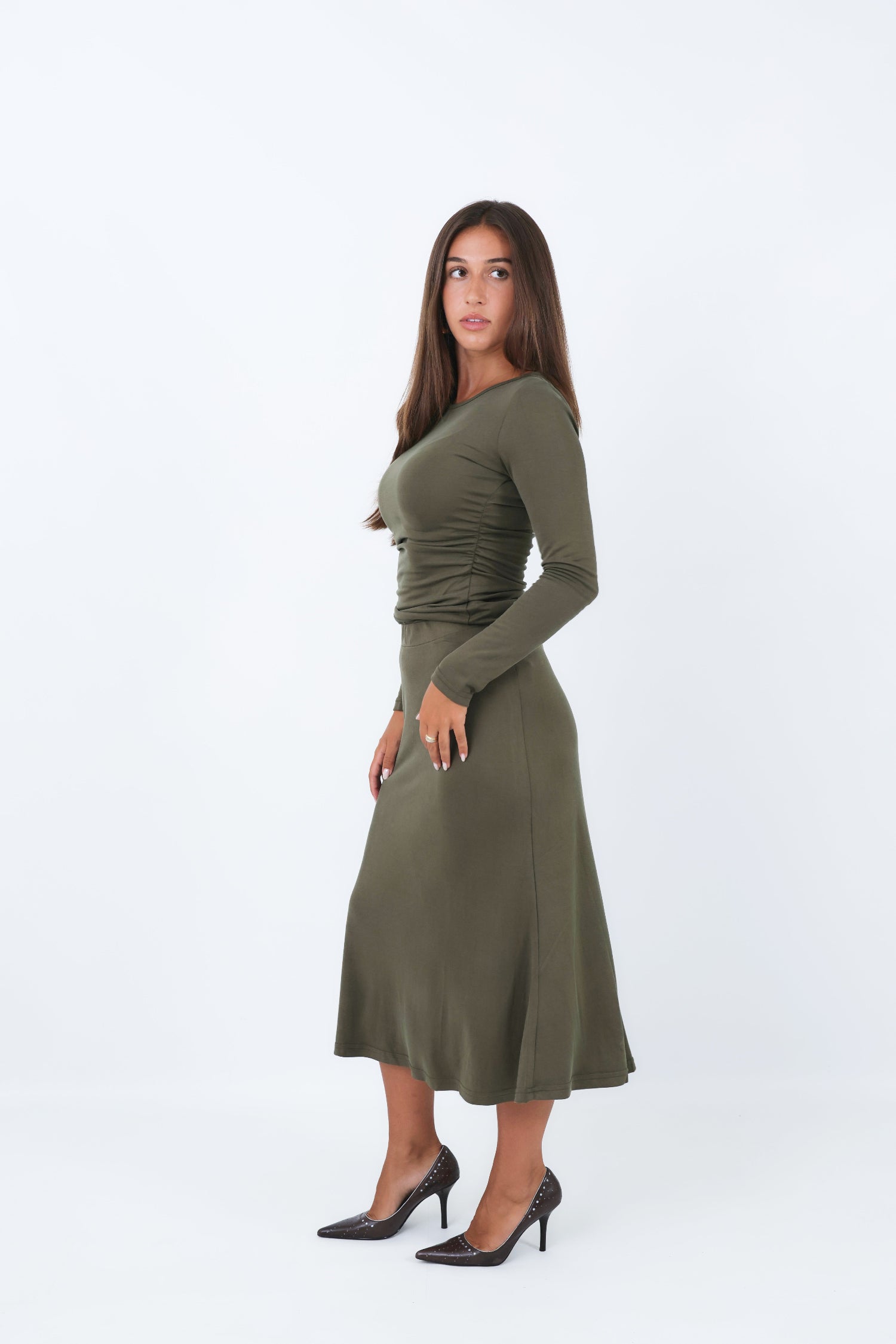 Woman wearing a utility green skirt and matching shirt on a white background